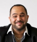 Elysium Odyssey - Beyond the Horizons author portrait, showing a smiling man with short dark hair, a trimmed beard, and black jacket